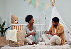 Pregnant and baby room and black couple happy to prepare for a family home and folding clothes. Man and woman together talking about excited pregnancy future, love and life insurance on bedroom floor