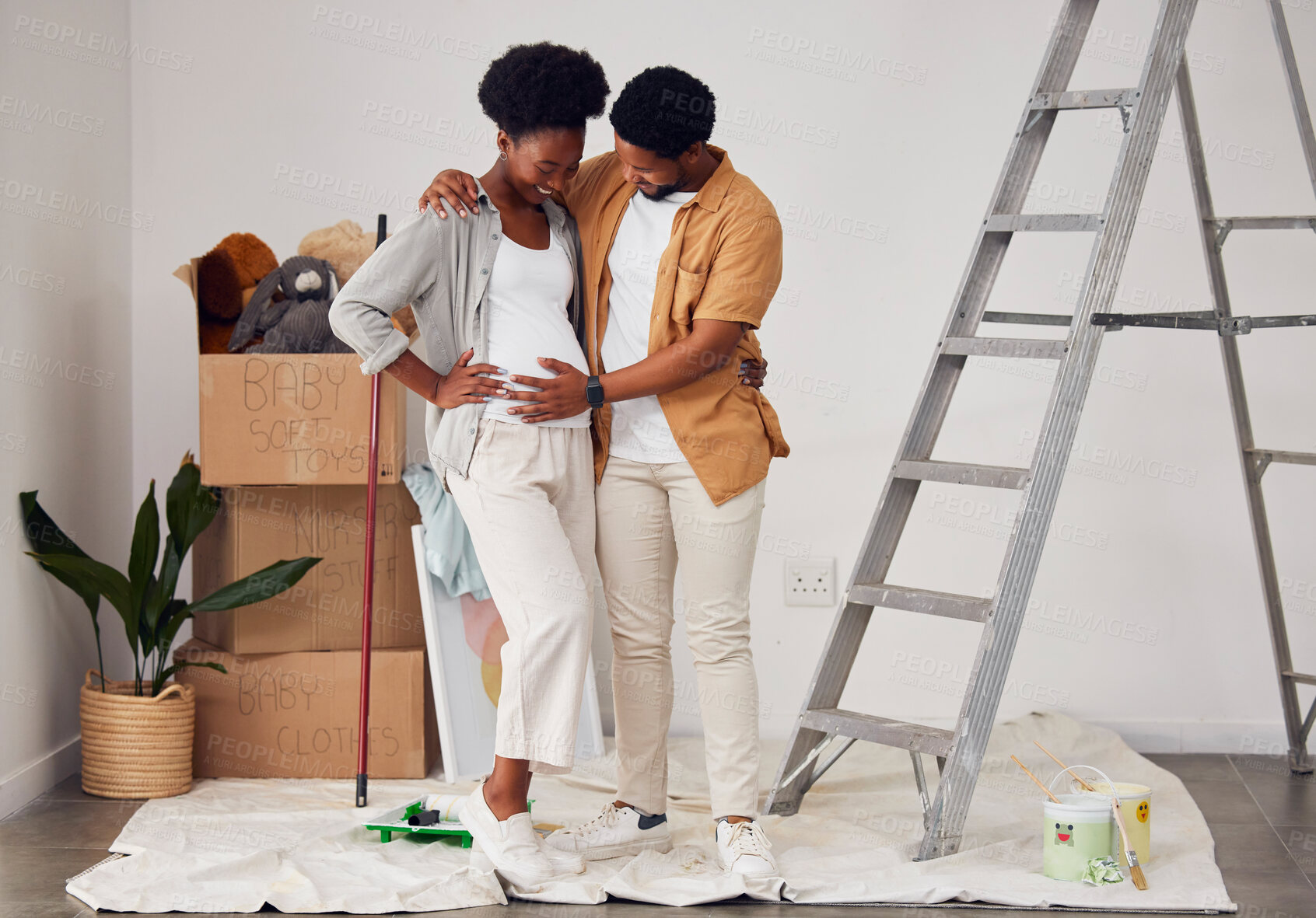 Buy stock photo Painting, pregnancy or black couple hug in home renovation, diy or house remodel together by apartment ladder. Teamwork, people or African man and pregnant woman excited about baby or new family