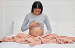 Pregnant, hands on stomach and mother in bed holding abdomen for baby, infant and child affection at home. Pregnancy love, family and excited, loving and happy woman rest, relax and calm in bedroom