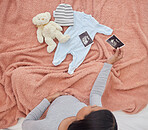 Pregnant, baby clothes and mother with scan, x ray and teddy bear in bed of kid, infant and child. Pregnancy love, family home and top view of excited and happy woman with prenatal picture in bedroom