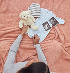 Baby clothes, scan and pregnant woman preparing for her child or infant in the nursery or bedroom. Pregnancy, love and maternal female looking at a teddy bear, outfit and xray of newborn kid at home.