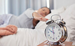 Woman, bed and alarm clock with snooze, sleeping and tired in morning with blurred background in home. Bedroom, watch and wake up time after sleep, rest and relax with burnout, apartment or house