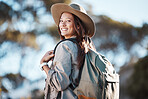 Hiking, portrait and woman in nature for freedom, travel and backpacking adventure on blurred background. Face, girl and traveler walking in a forest, smile and excited for journey, vacation or trip