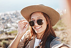 Woman, portrait and selfie in nature for travel, relax and hiking against city background. Face, girl and fitness influencer live streaming for social media, blog or post, smile and profile picture