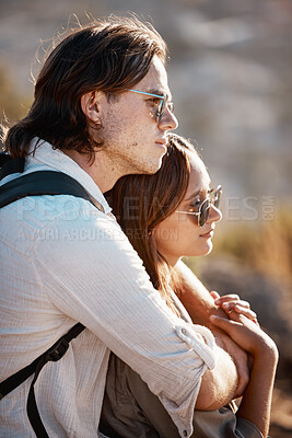 Buy stock photo Love, outdoor and couple hugging while on a hike on a mountain while on vacation or weekend trip. Romance, happy and young man embracing his girlfriend from behind while trekking together on holiday.
