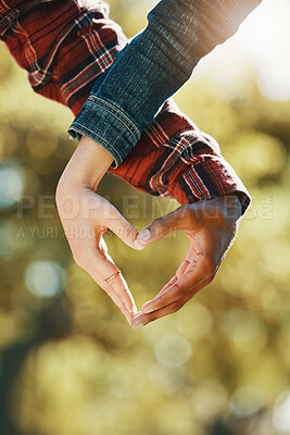 Buy stock photo Love, care and hands of a couple in a heart for support, diversity and trust in nature. Emoji, marriage and gesture from a man and woman showing emotion, romance and affection on valentines day