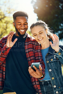 Buy stock photo Video call, hello and couple of friends at park for social media update, live streaming date and influencer talking. Interracial people, online 5g communication and international holiday or vacation
