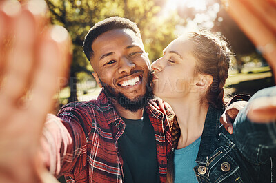 Buy stock photo Interracial couple, selfie kiss and portrait in nature, having fun and bonding together outdoors. Smile, love romance and black man and woman kissing to take photo for happy memory or social media.