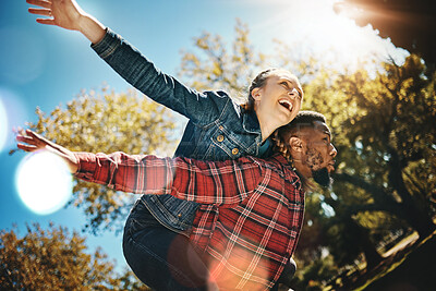 Buy stock photo Young couple, flying and piggyback in park, summer and date together in sunshine, happiness or nature. Happy man carrying woman in garden of love, care and freedom to play, smile or diversity partner