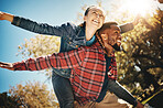 Happy couple, flying arms and piggyback in park, summer and date together in sunshine, happiness and support. Below of man carrying woman in garden for love, care and freedom with diversity partner