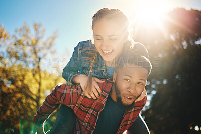 Buy stock photo Interracial couple, sunshine and piggyback in park, summer and outdoor date together for happiness, smile and nature. Happy man carrying woman in garden for love, care and relax for diversity partner