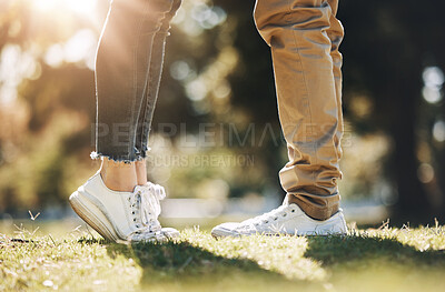 Buy stock photo Couple, legs and feet standing on grass field for love, affection or bonding together in nature. Leg of woman raising foot for height with man for loving care, touch or embrace in the park outdoors