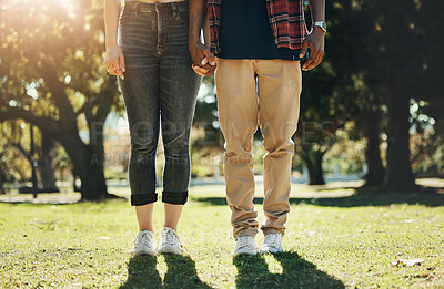Buy stock photo Love, holding hands and shoes of interracial couple in park for calm, freedom or support. Relax, happy and peace with feet of black man and woman standing in grass field for nature, spring or bonding