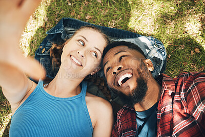 Buy stock photo Interracial couple, park selfie and lying on grass with smile, love and happiness to relax on holiday. Black man, woman and profile picture on lawn for social media app with romance, above and care