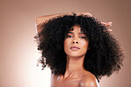 Beauty, hair and portrait of black woman in studio for self care with shampoo for growth. Aesthetic model with natural curly afro with cosmetics, skincare glow and face makeup on gradient background