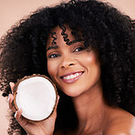 Black woman, studio portrait and coconut with smile, skincare and health with self care by beige background. Happy gen z model, african and fruit for natural aesthetic, healthy nutrition and cosmetic