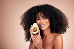 Black woman, studio portrait and avocado for beauty, cosmetic skincare or health for wellness, smile or self care. Happy gen z model, african or fruit for natural aesthetic, healthy nutrition or diet