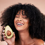 Black woman, studio and avocado for beauty, smile and skincare with health, wellness and self care by background. Happy gen z model, african and fruit for natural aesthetic, healthy nutrition or diet