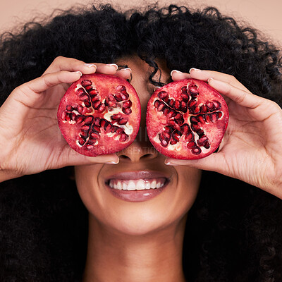 Buy stock photo Hair care, face and black woman with pomegranate in studio isolated on a brown background. Fruit, skincare and happy female model holding food for healthy diet, nutrition or vitamin c and minerals.
