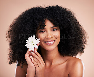 Buy stock photo Black woman, studio portrait and flower with smile, beauty and cosmetic wellness by beige background. African gen z model, lotus plant and spring aesthetic with happiness, health and natural makeup