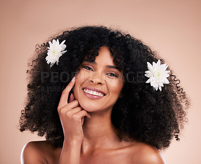 Buy stock photo Portrait, hair care and black woman with flowers, smile and texture with girl on brown studio background. Face, African American female and lady with plants, florals and confident with afro or volume