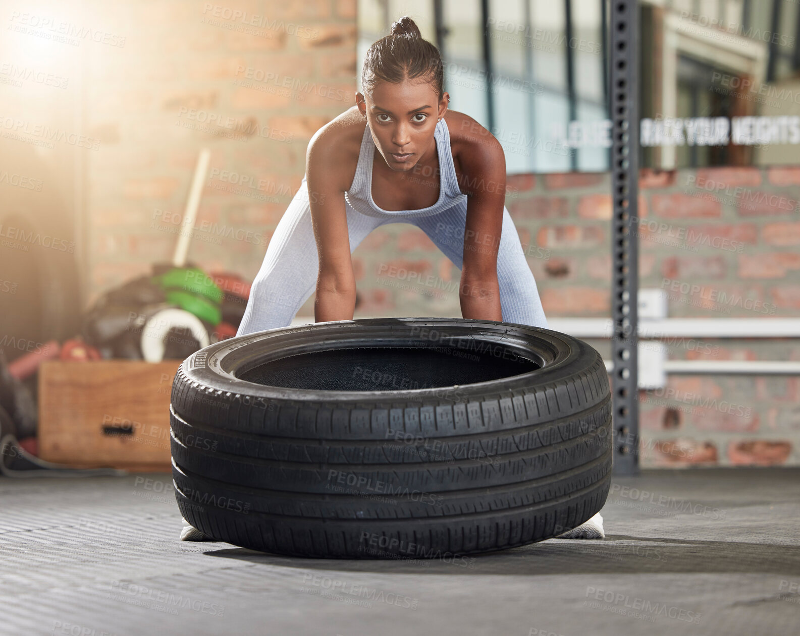 Buy stock photo Exercise, fitness and portrait of woman with tire at gym for health and wellness with training workout. Indian athlete person focus on hard work and commitment to train for strong body goals or power