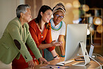 Collaboration, business and a woman manager with her team, working on a computer in the office at night. Teamwork, diversity and coaching with a senior female manager training her staff at work