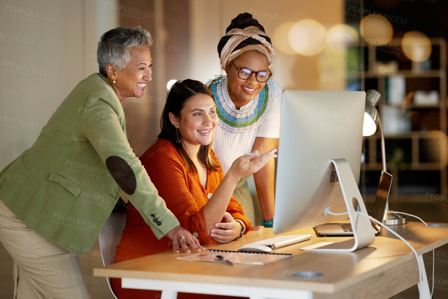 Buy stock photo Collaboration, management and a business woman with her team, working on a computer in the office at night. Teamwork, diversity and coaching with a senior female manager training her staff at work