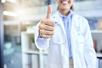 Healthcare, help and woman doctor with thumbs up, success and motivation at hospital or clinic with smile. Confidence, health achievement and medical employee with hand gesture in support in medicine
