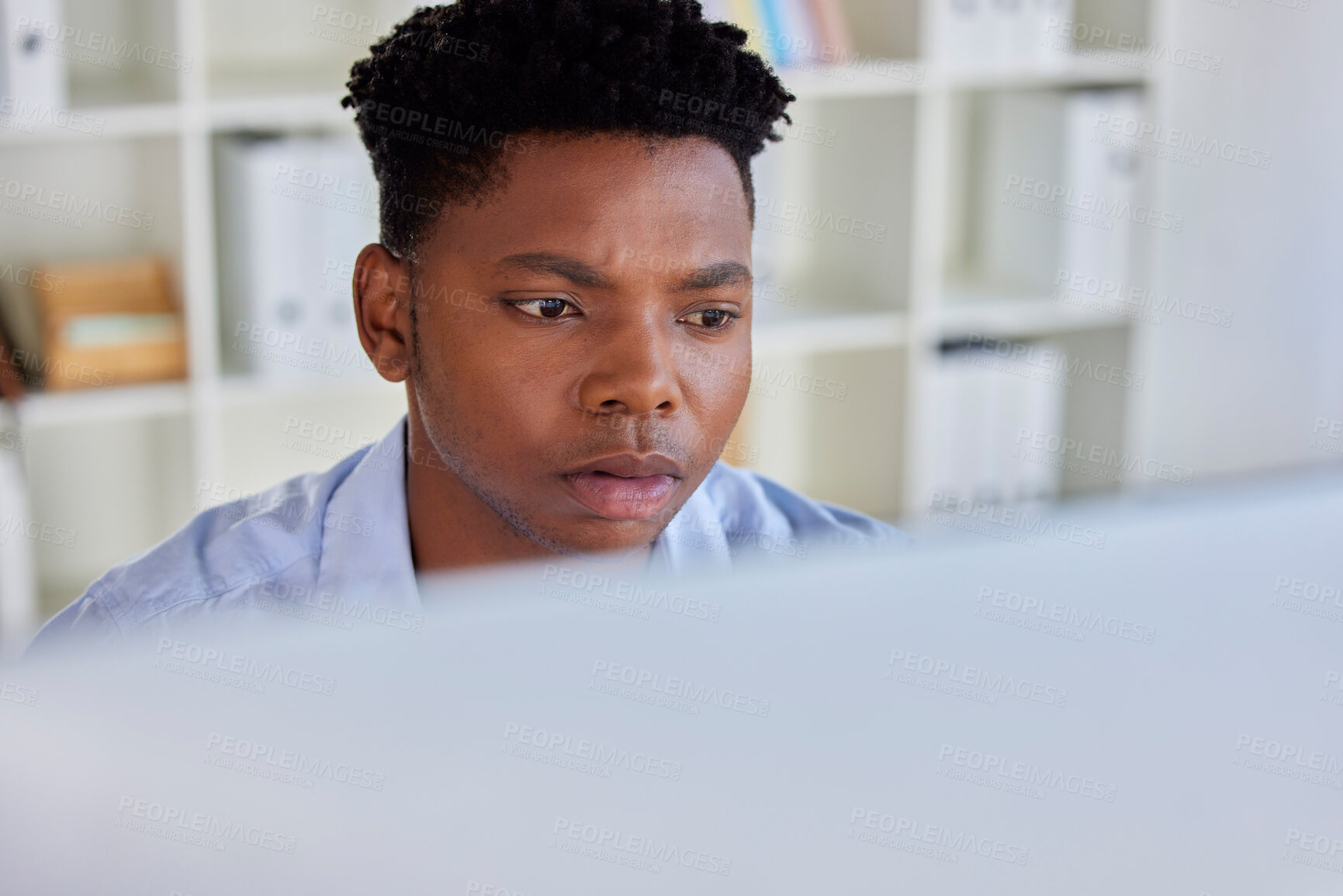 Buy stock photo Serious, black man and business analyst at a office computer reading digital data. Businessman, research and financial project planning of a startup employee working and thinking of web decision