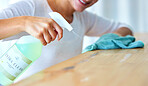 Closeup, hands and woman with spray bottle, detergent and hygiene for protection, wellness and spring cleaning. Zoom, female cleaner and lady with liquid, table and surface disinfection and safety