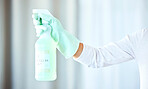 Bottle in hand, arm and spray for cleaning, cleaner and housekeeping with chemical, person with glove for safety. Housekeeper, disinfectant liquid to clean bacteria for hygiene and house work