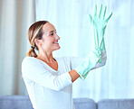 Woman, gloves and cleaning for hygiene, disinfectant and cleaner ready to start the day, housekeeping and sanitary. Female, lady and maid in living room, dust and dirt with bacteria and rubber safety