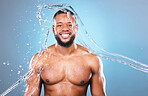 Muscle, portrait and water on man cleaning, hygiene and skincare isolated in studio blue background. Bodybuilder, aqua and model washing smooth skin with glow smile and happy for wellness
