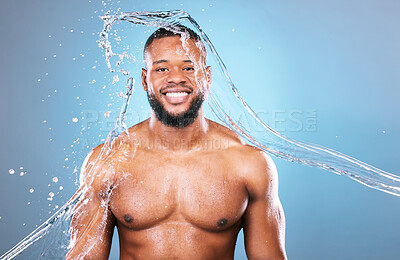 Buy stock photo Muscle, portrait and water on black man cleaning, hygiene and skincare isolated in studio blue background. Bodybuilder, aqua and model washing smooth skin with glow smile and happy for wellness