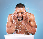 Water, cleaning and beauty with a black man in studio on a blue background for hygiene or hydration. Splash, face and skincare with a male washing his skin in the bathroom for natural body care