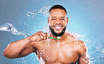 Black man, face and toothbrush with water and dental, brushing teeth and hygiene on blue background. Cleaning, wet splash and grooming, male in portrait and smile for oral care product and toothpaste