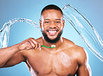 Black man, face and toothbrush with splash of water, dental and brushing teeth for hygiene on blue background. Cleaning, wet and male in portrait with smile for oral care product and toothpaste