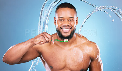Buy stock photo Black man, face and toothbrush with water splash and dental, brushing teeth and hygiene on blue background. Cleaning, wet and grooming, male in portrait and smile for oral care product and toothpaste