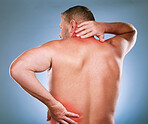 Back, man and pain with inflammation, injury and body ache with blue studio background. Mature male, gentleman or emergency with neck, bruise or broken with red highlight for muscle tension or strain