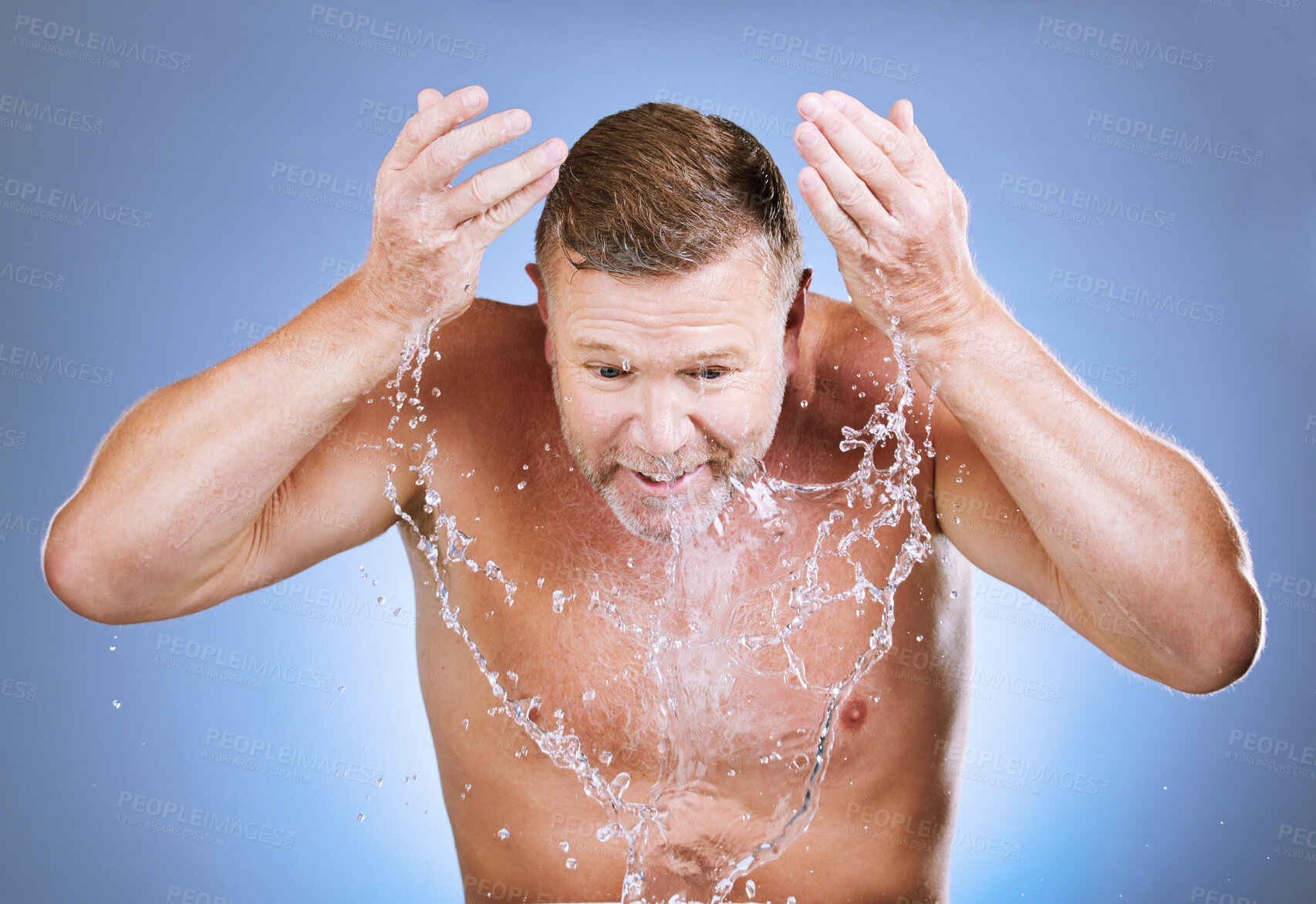 Buy stock photo Man, water splash and cleaning face for skincare, wellness shower or blue background. Mature model, male beauty and clean facial for aesthetic, healthy glow and morning dermatology on studio backdrop