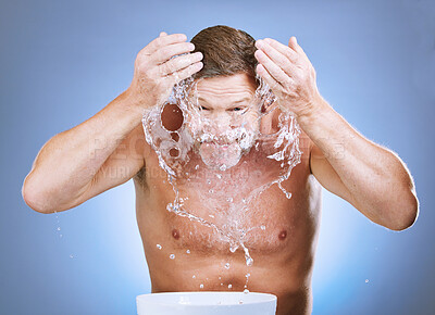 Buy stock photo Man, water splash and skincare hygiene by basin for face wash or natural sustainability against blue studio background. Male washing in facial treatment by sink for clean wellness or self care