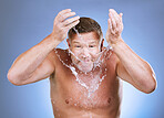 Water splash, man and face portrait for skincare, wellness shower or blue background. Mature model, male beauty and clean facial for aesthetic, healthy glow and morning dermatology on studio backdrop