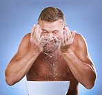 Man cleaning face, hands and water splash, hygiene and grooming with clean facial on blue background. Senior male washing skin, basin and morning routine with natural cosmetic care and dermatology