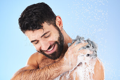 Buy stock photo Shower, loofah and man in studio for grooming, hygiene and wellness with soap against blue background. Body care, skincare and male model relax with luxury, foam and product, exfoliation and cleaning