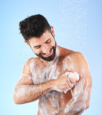 Buy stock photo Soap, shower and man with water splash, smile and hygiene in studio for wellness, cleaning and grooming. Skincare, healthy skin and happy male with foam, cosmetics and washing body on blue background
