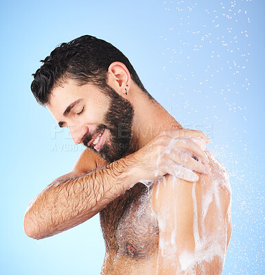 Buy stock photo Shower, cleaning and man with water, smile and soap in studio for wellness, hygiene and grooming. Skincare, healthy skin and happy male with foam, bath cosmetics and washing body on blue background