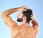 Hair care, shower wash and man model in water for cleaning, skincare and hygiene wellness. Isolated, blue background and studio with a young person in bathroom for dermatology and self care routine