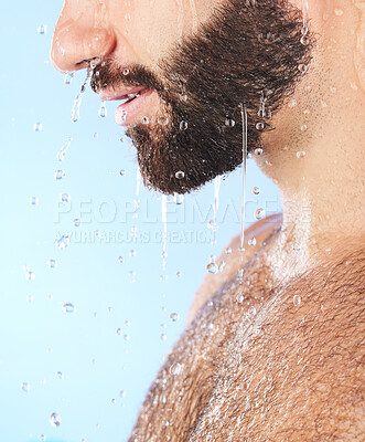 Buy stock photo Man face, shower and profile of a model in water for cleaning, skincare and hygiene wellness. Isolated, blue background and studio with young person in bathroom for dermatology and beard self care 
