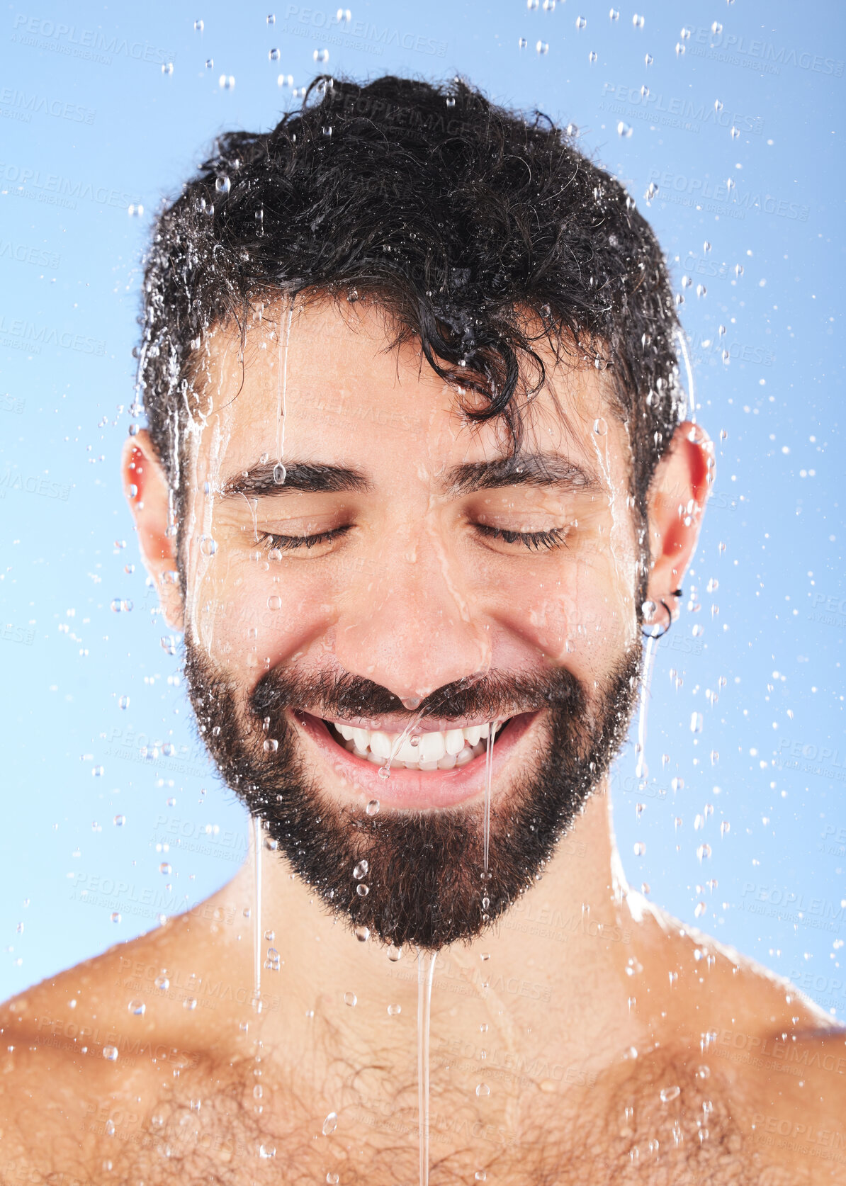Buy stock photo Man, shower water and smile of a model for beauty cleaning, skincare and hygiene wellness. Isolated, blue background and studio with a young person in bathroom for dermatology and self care routine